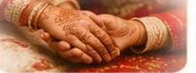 A bride's hands decorated with henna and bangles